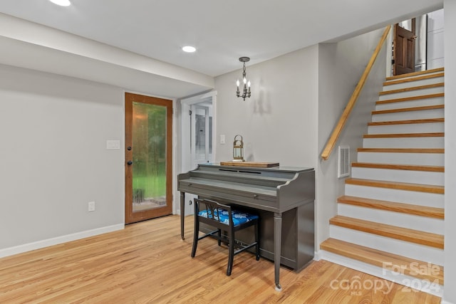 misc room with light hardwood / wood-style floors and a chandelier