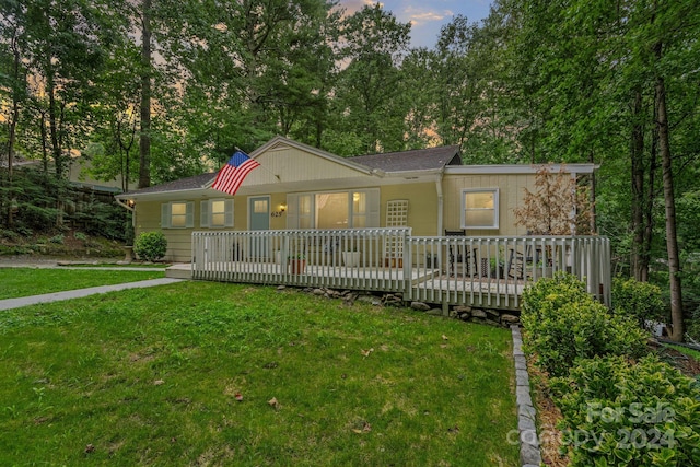 view of front facade featuring a yard and a wooden deck