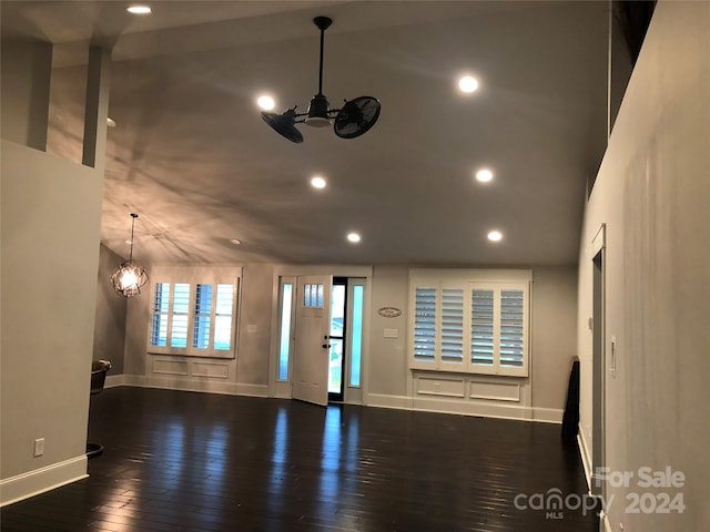 unfurnished living room with a towering ceiling, dark hardwood / wood-style flooring, and a chandelier