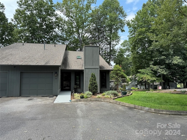 view of front of home with a garage and a front lawn