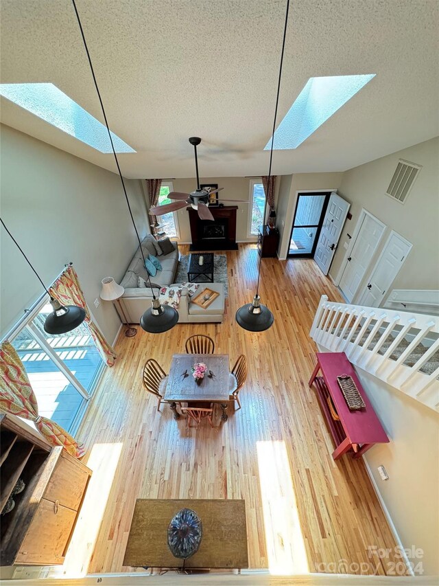 living room with wood-type flooring, a skylight, and a textured ceiling