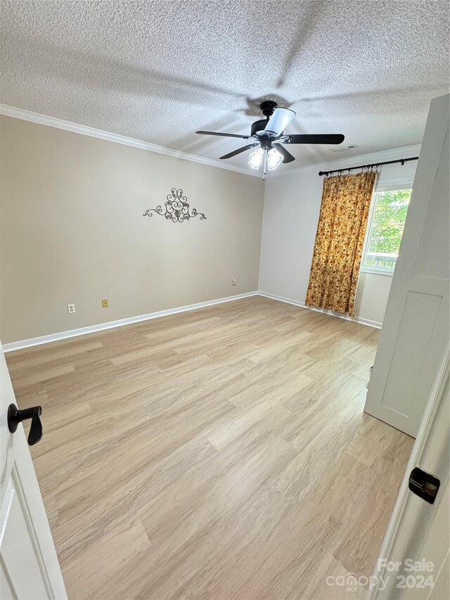 spare room with light hardwood / wood-style floors, crown molding, ceiling fan, and a textured ceiling