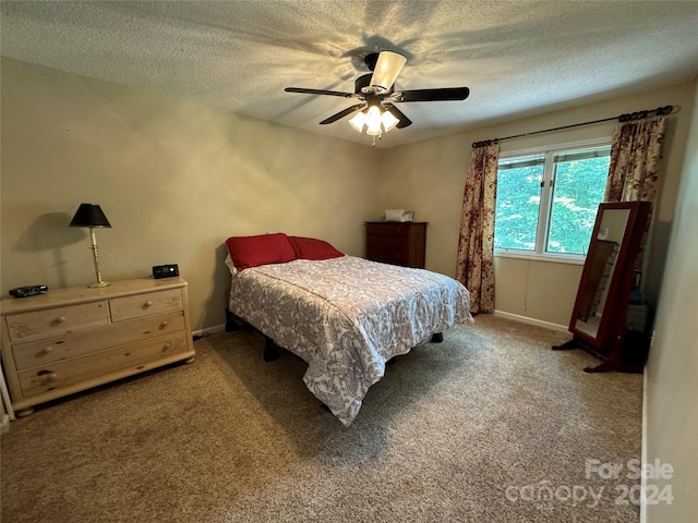 carpeted bedroom with ceiling fan and a textured ceiling