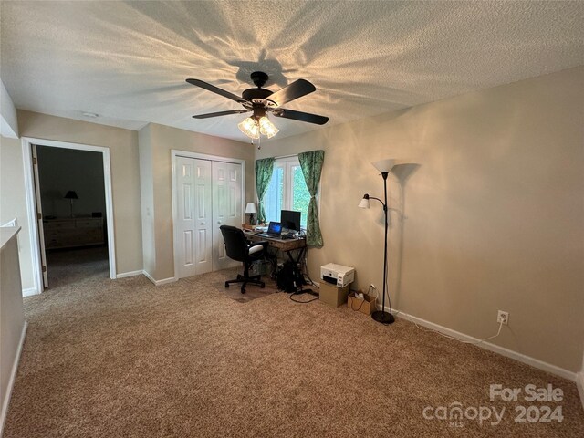 unfurnished office featuring ceiling fan, a textured ceiling, and carpet floors