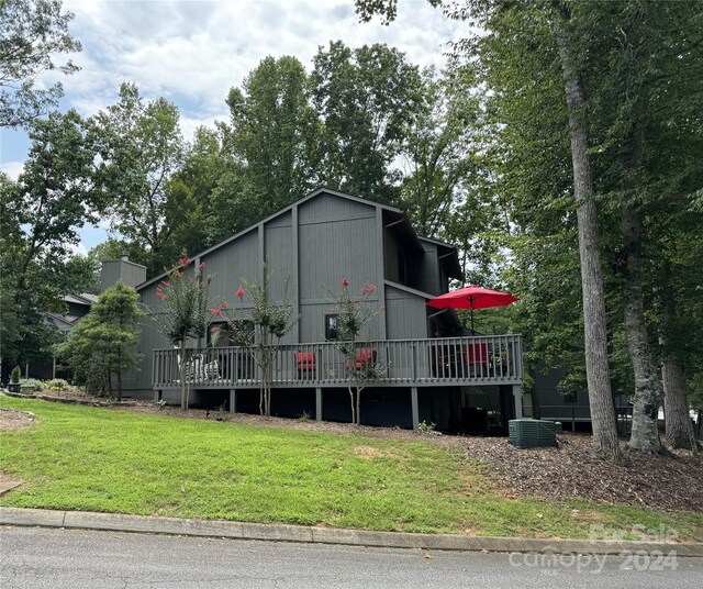 exterior space with central AC, a deck, and a front yard