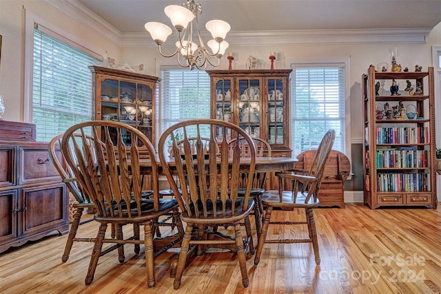 dining space with light hardwood / wood-style flooring, ornamental molding, and a chandelier