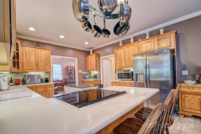 kitchen with a kitchen bar, sink, stainless steel fridge with ice dispenser, kitchen peninsula, and backsplash