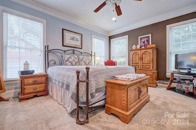 carpeted bedroom with multiple windows, ornamental molding, and ceiling fan