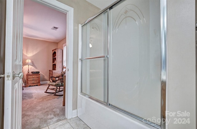 bathroom with bath / shower combo with glass door and tile patterned floors