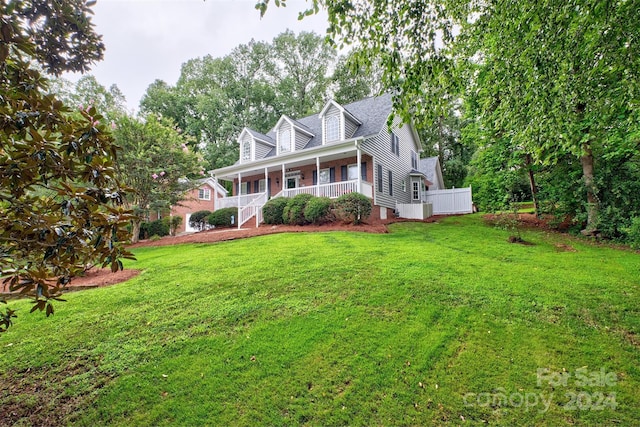 cape cod home with a front lawn and covered porch