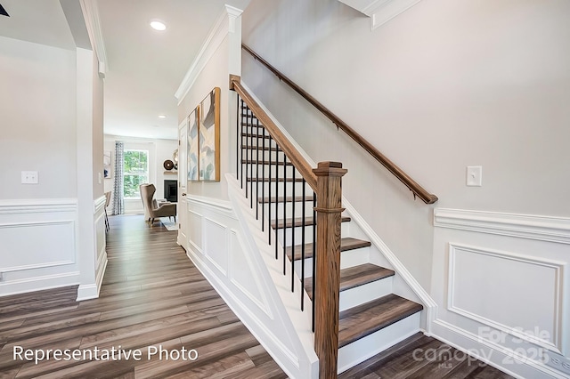 staircase featuring crown molding and wood-type flooring