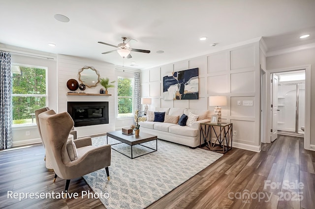 living room with a wealth of natural light, ornamental molding, and dark hardwood / wood-style floors