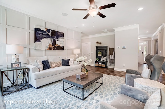 living room featuring hardwood / wood-style flooring, ornamental molding, and ceiling fan