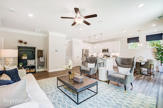 living room with crown molding, hardwood / wood-style flooring, and ceiling fan