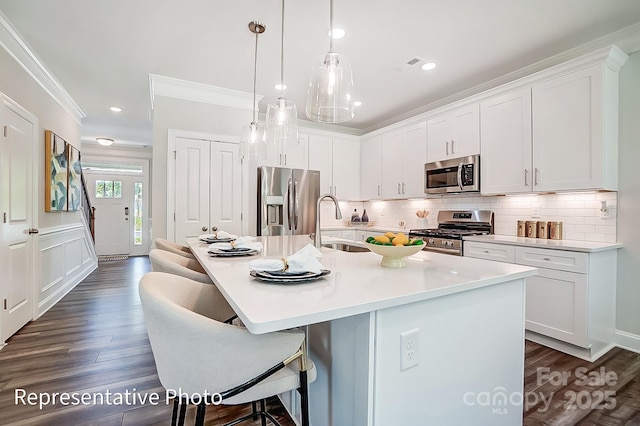 kitchen with white cabinetry, appliances with stainless steel finishes, and an island with sink