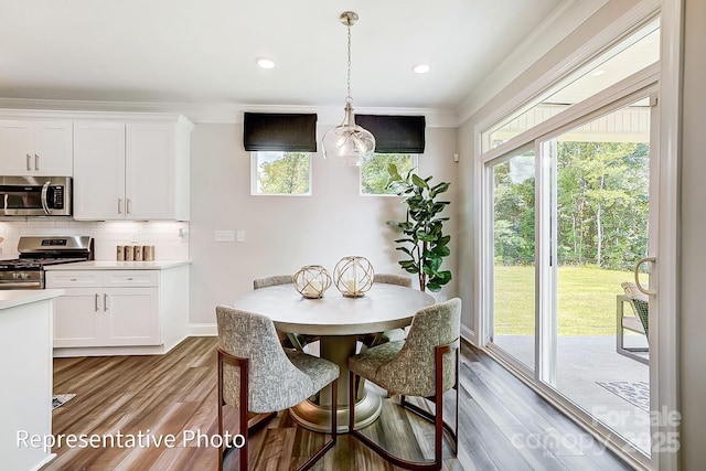 dining area with crown molding and light wood-type flooring