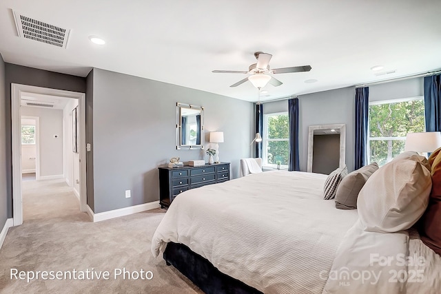 carpeted bedroom with multiple windows and ceiling fan