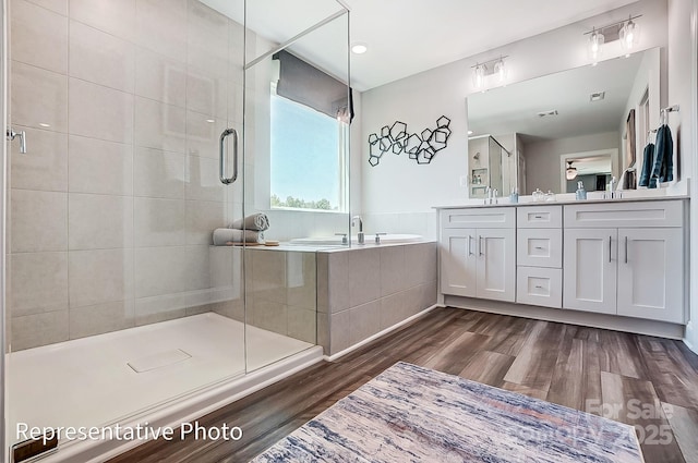 bathroom featuring vanity, hardwood / wood-style flooring, and shower with separate bathtub