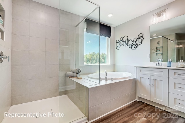 bathroom with vanity, hardwood / wood-style floors, and plus walk in shower