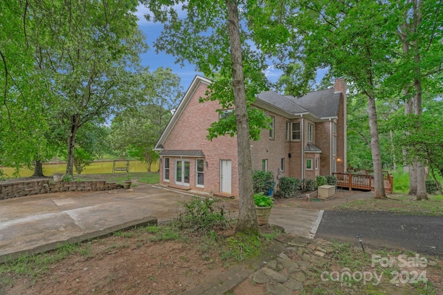 view of side of property featuring a wooden deck