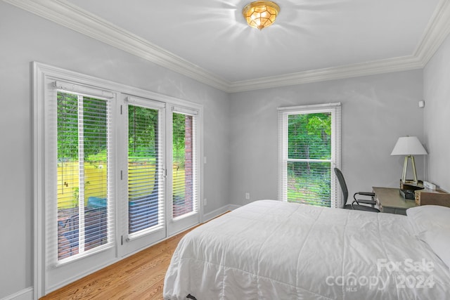 bedroom featuring light hardwood / wood-style flooring, multiple windows, access to outside, and ornamental molding