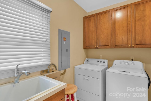 laundry room with cabinets, washer and dryer, sink, and electric panel