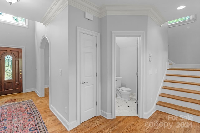 foyer with light hardwood / wood-style flooring and ornamental molding