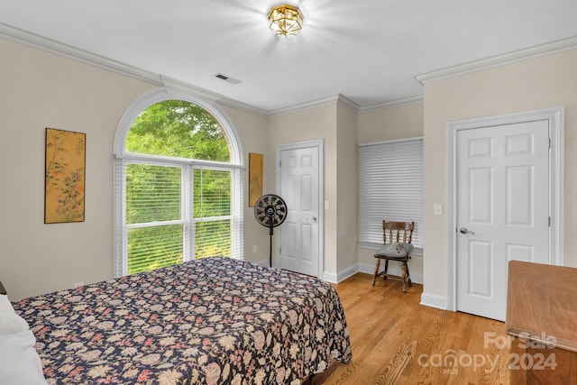 bedroom featuring ornamental molding and light hardwood / wood-style floors