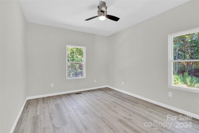 unfurnished room featuring ceiling fan, wood finished floors, visible vents, and baseboards