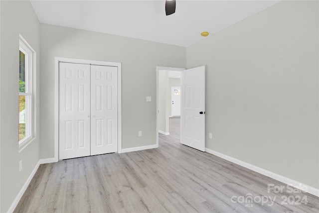 unfurnished bedroom featuring a closet, ceiling fan, baseboards, and wood finished floors