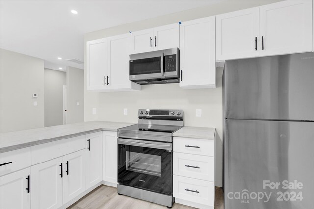 kitchen with white cabinetry, light hardwood / wood-style floors, and stainless steel appliances