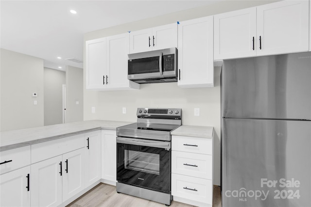 kitchen featuring light wood-type flooring, white cabinetry, appliances with stainless steel finishes, and recessed lighting