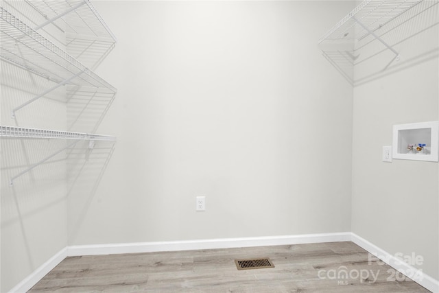 laundry area featuring washer hookup, visible vents, wood finished floors, laundry area, and baseboards