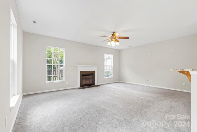 unfurnished living room with ceiling fan and light colored carpet