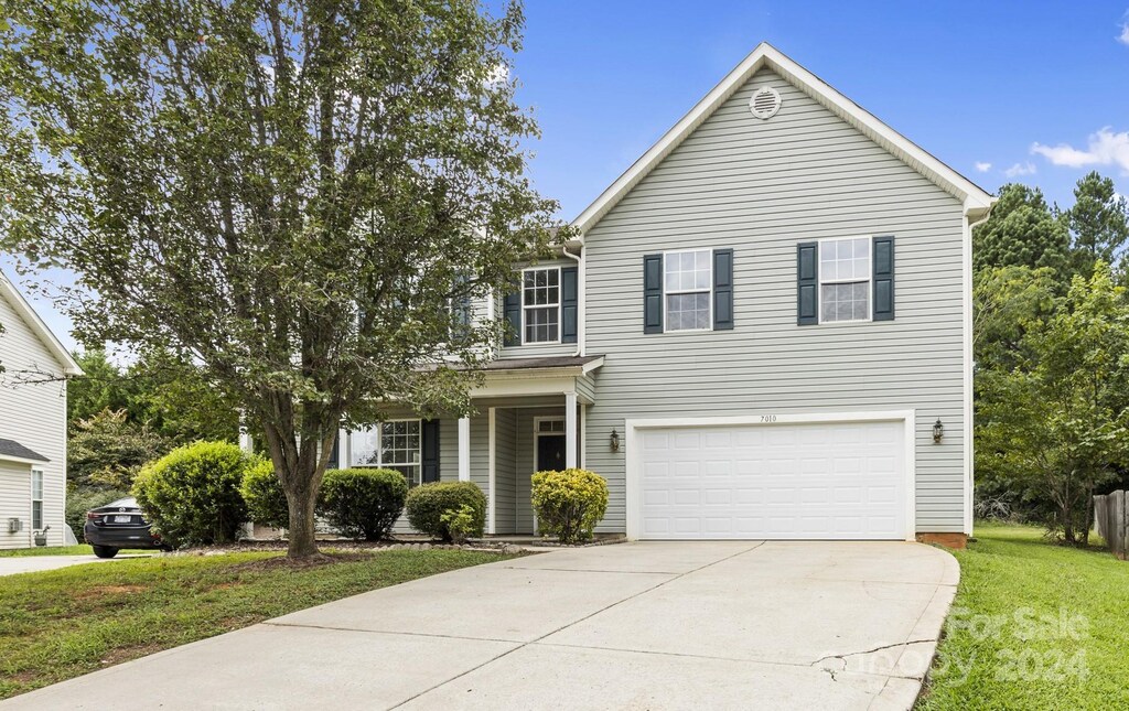 front facade featuring a garage and a front yard