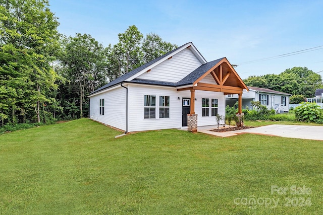 view of front of property with a front yard and roof with shingles