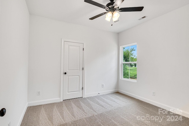 carpeted spare room featuring ceiling fan