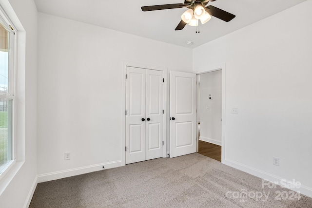 unfurnished bedroom featuring a closet, carpet, and ceiling fan