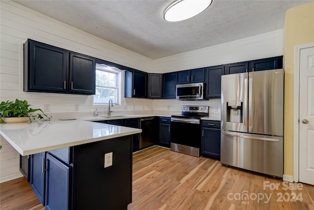 kitchen with sink, a breakfast bar area, stainless steel appliances, blue cabinets, and kitchen peninsula