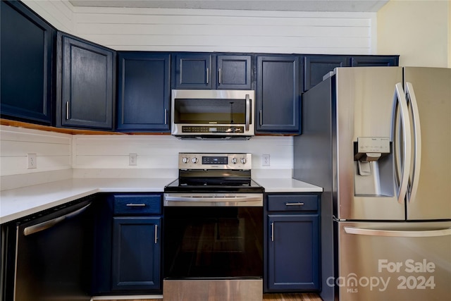 kitchen with blue cabinetry and appliances with stainless steel finishes