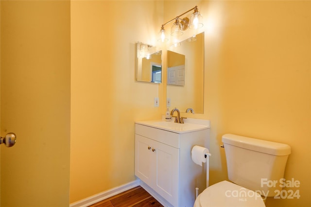 bathroom featuring vanity, hardwood / wood-style flooring, and toilet