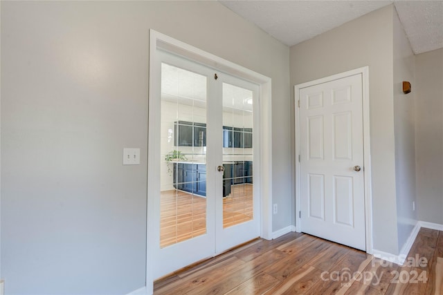 entryway featuring hardwood / wood-style flooring, french doors, and a textured ceiling