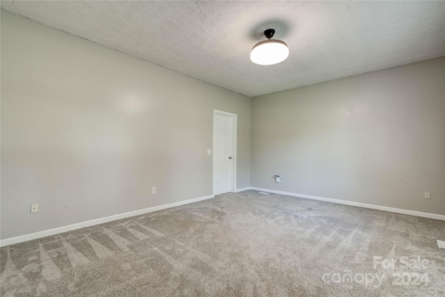 unfurnished room with carpet floors and a textured ceiling