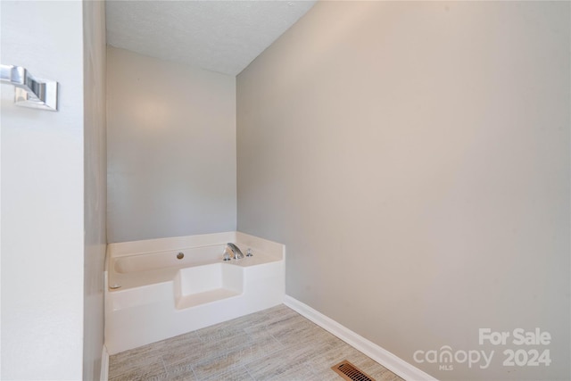 bathroom featuring a bath and a textured ceiling