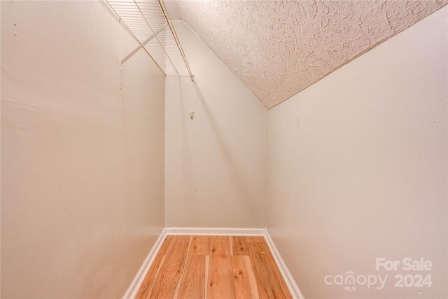 spacious closet with hardwood / wood-style flooring and lofted ceiling