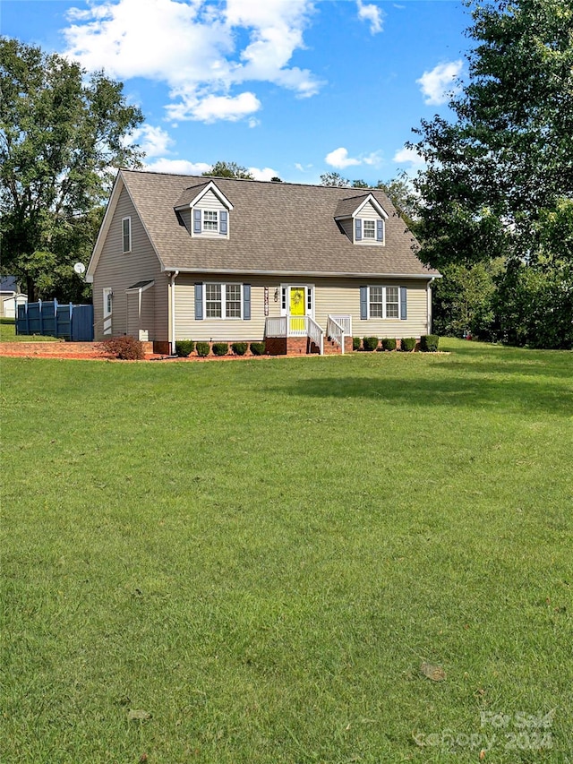 cape cod-style house with a front yard