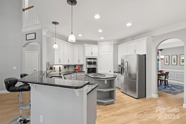 kitchen with light hardwood / wood-style flooring, white cabinets, stainless steel appliances, tasteful backsplash, and kitchen peninsula