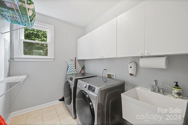 washroom featuring sink, cabinets, washer and dryer, and light tile patterned floors