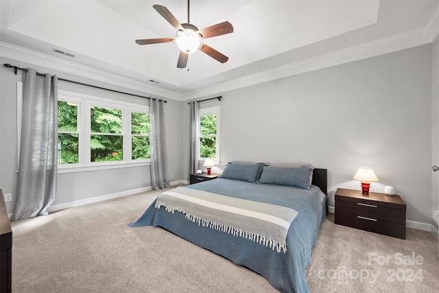 bedroom with crown molding, ceiling fan, a raised ceiling, and light colored carpet