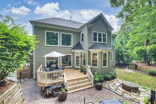 back of house with a wooden deck and a patio area